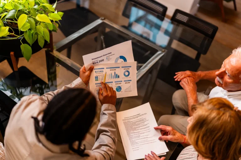 Adviser discusses financial statements with two people at the table